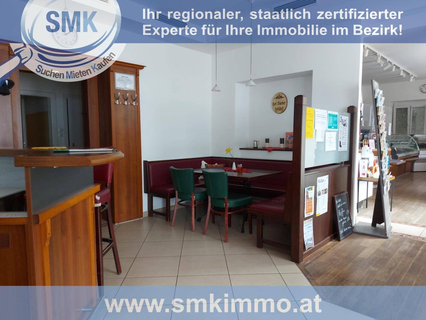 Gemütlicher Sitzbereich in einem Café mit gepolsterten Bänken, Tischen und einem Verkaufsdisplay.