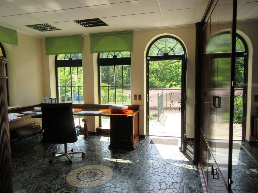 Helles Büro mit großen Bogenfenstern und Zugang zum Außenbereich, mit Mosaikboden.