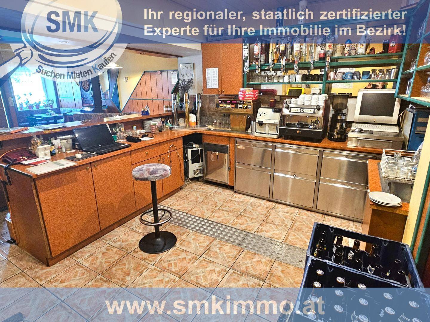 Gut ausgestattete Bar mit Theke, Zapfanlage und zahlreichen Flaschen im Regal.