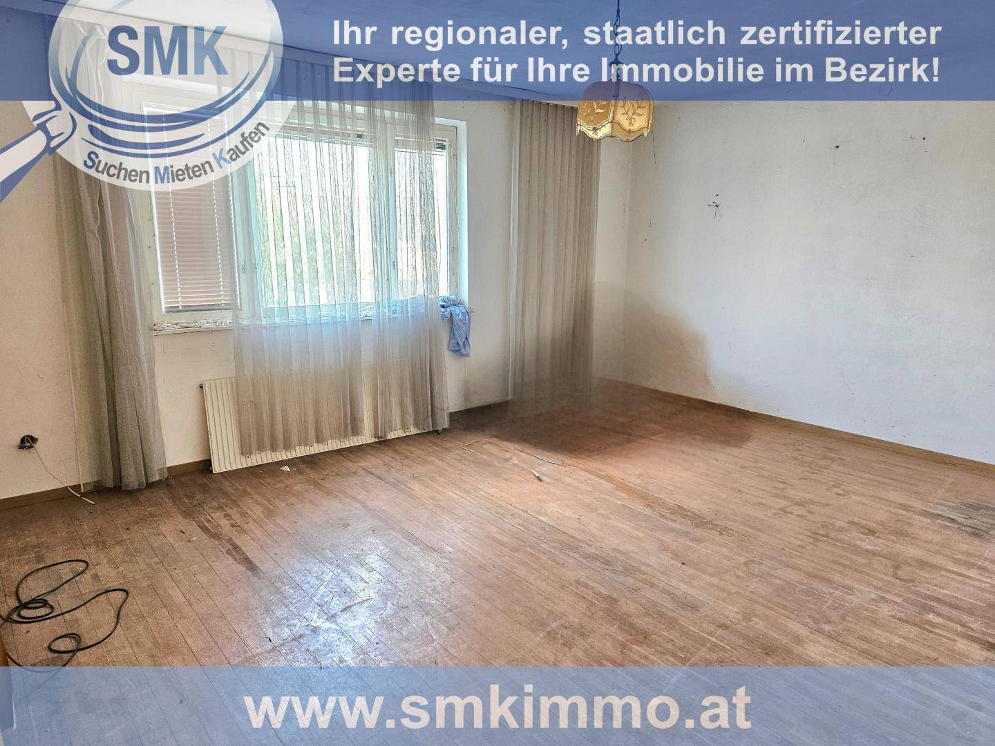 Renovierungsbedürftiger Raum mit altem Holzboden und großen Fenstern, wartet auf neue Gestaltung.