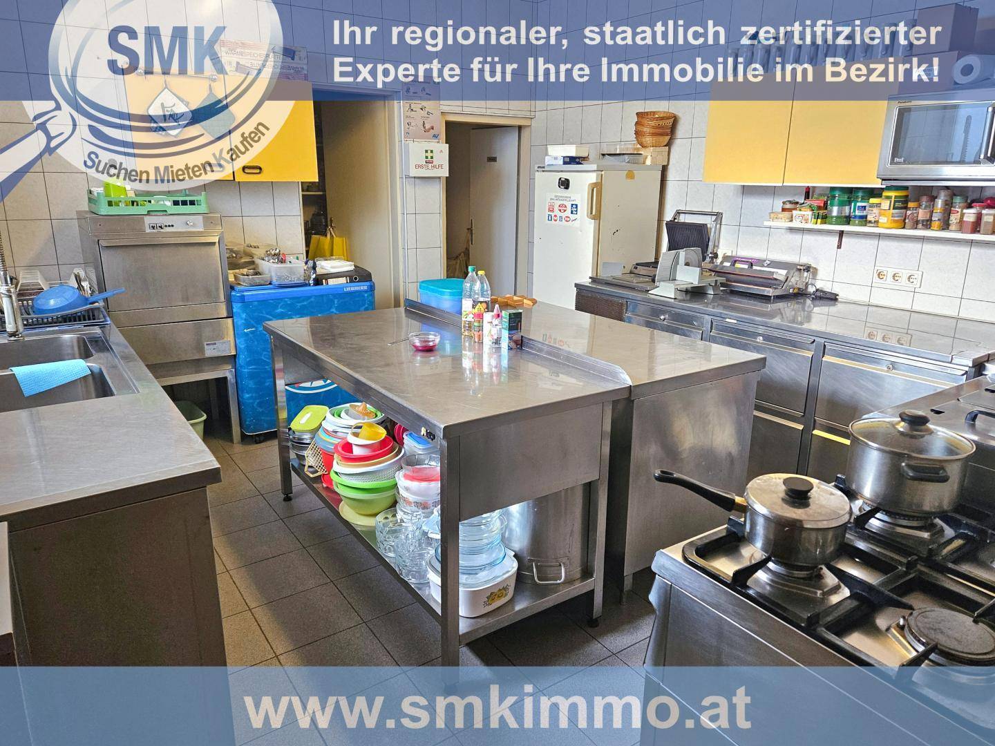 Große Edelstahlküche mit professionellen Geräten, Kochfeldern und Arbeitsflächen, ideal für Gastronomie.