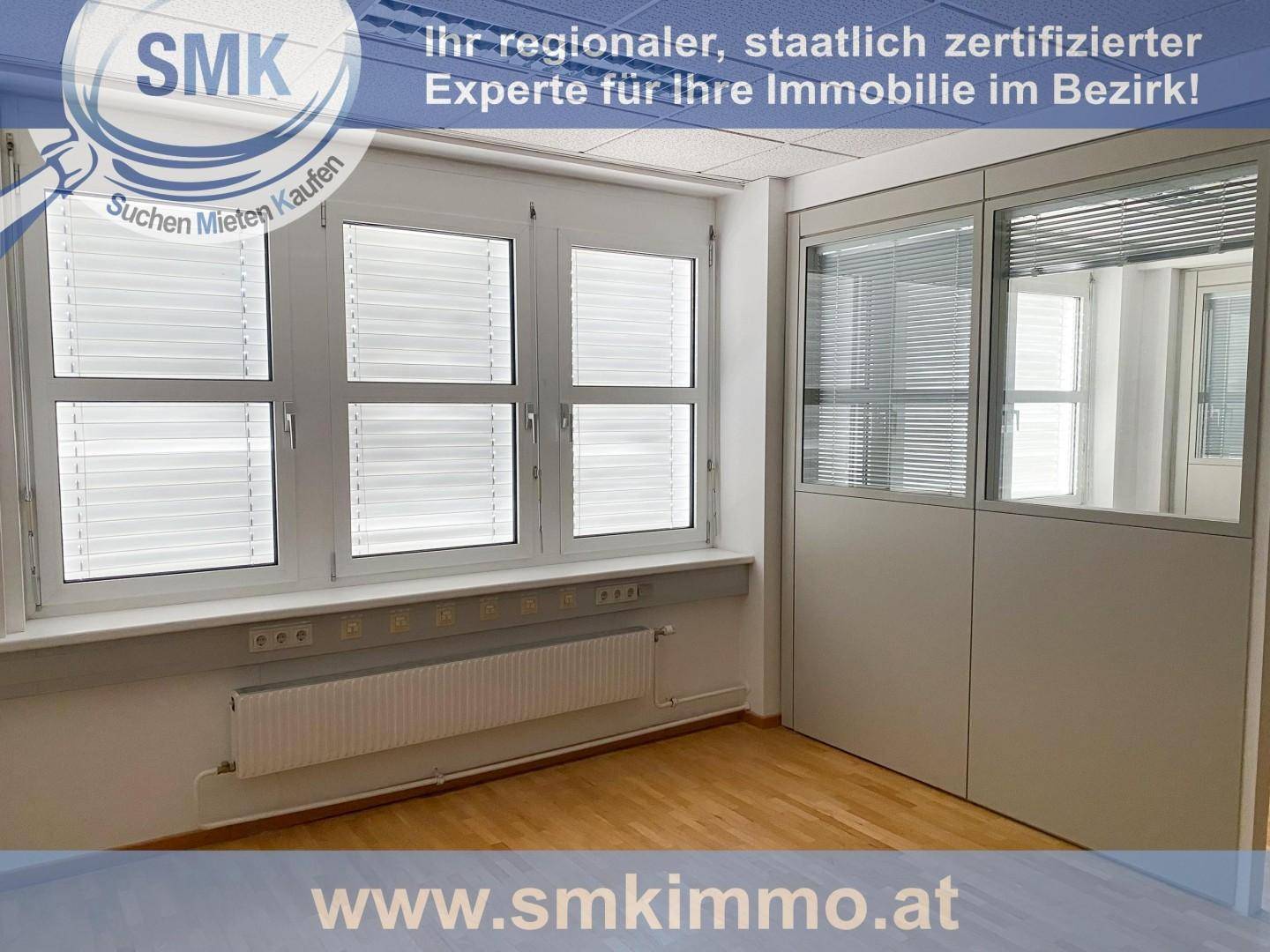 Büro mit großen Fenstern und Jalousien, hellem Holzfußboden und modernen Trennwänden mit Glaselementen.