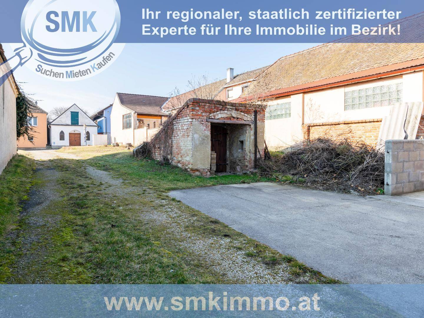 Unbefestigter Weg führt zu einem alten Ziegelbau, möglicherweise einem Keller oder einer Garage.