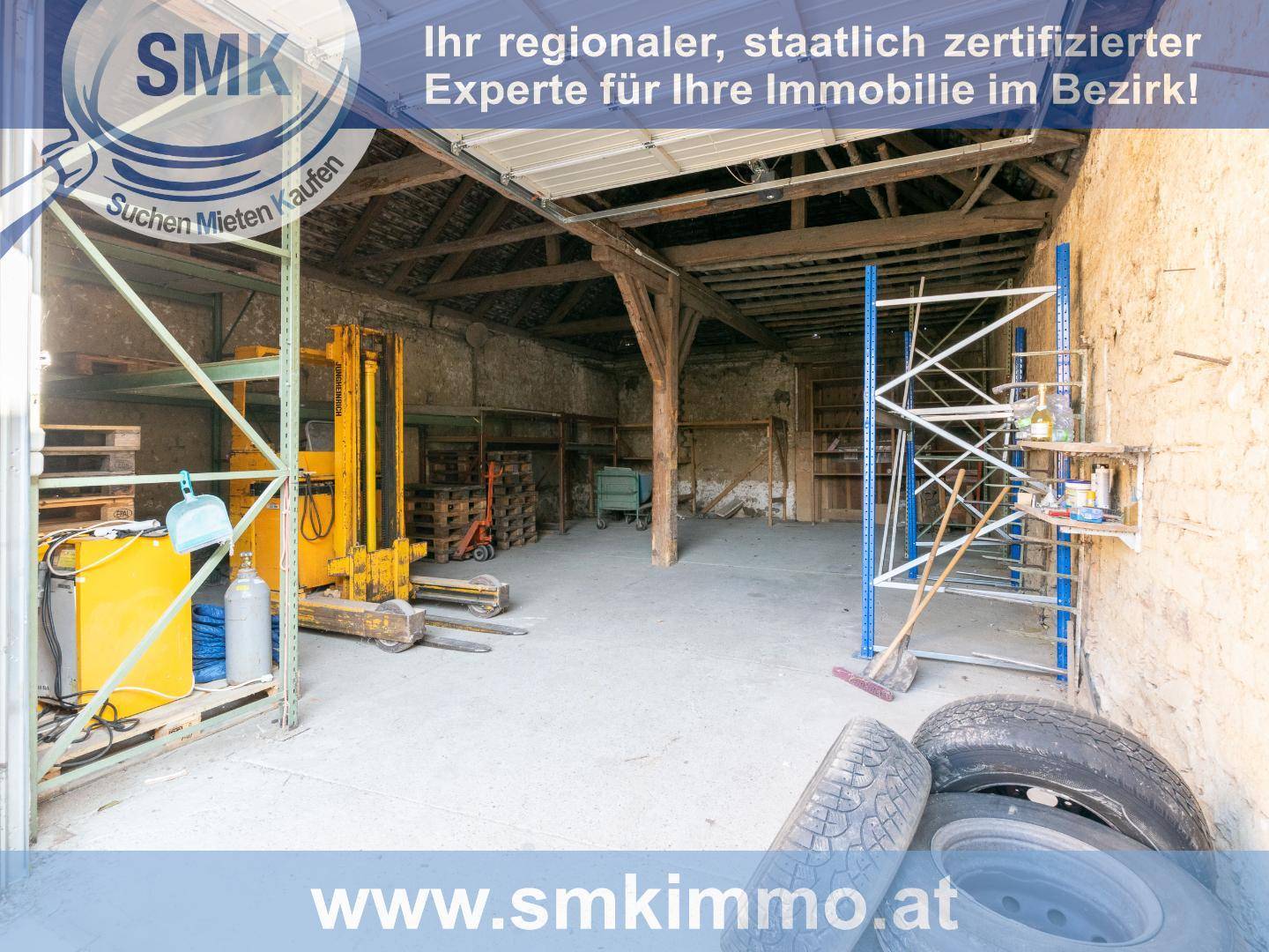 Großer rustikaler Werkstattraum mit Holzbalken und Betonboden, inklusive Gabelstapler.