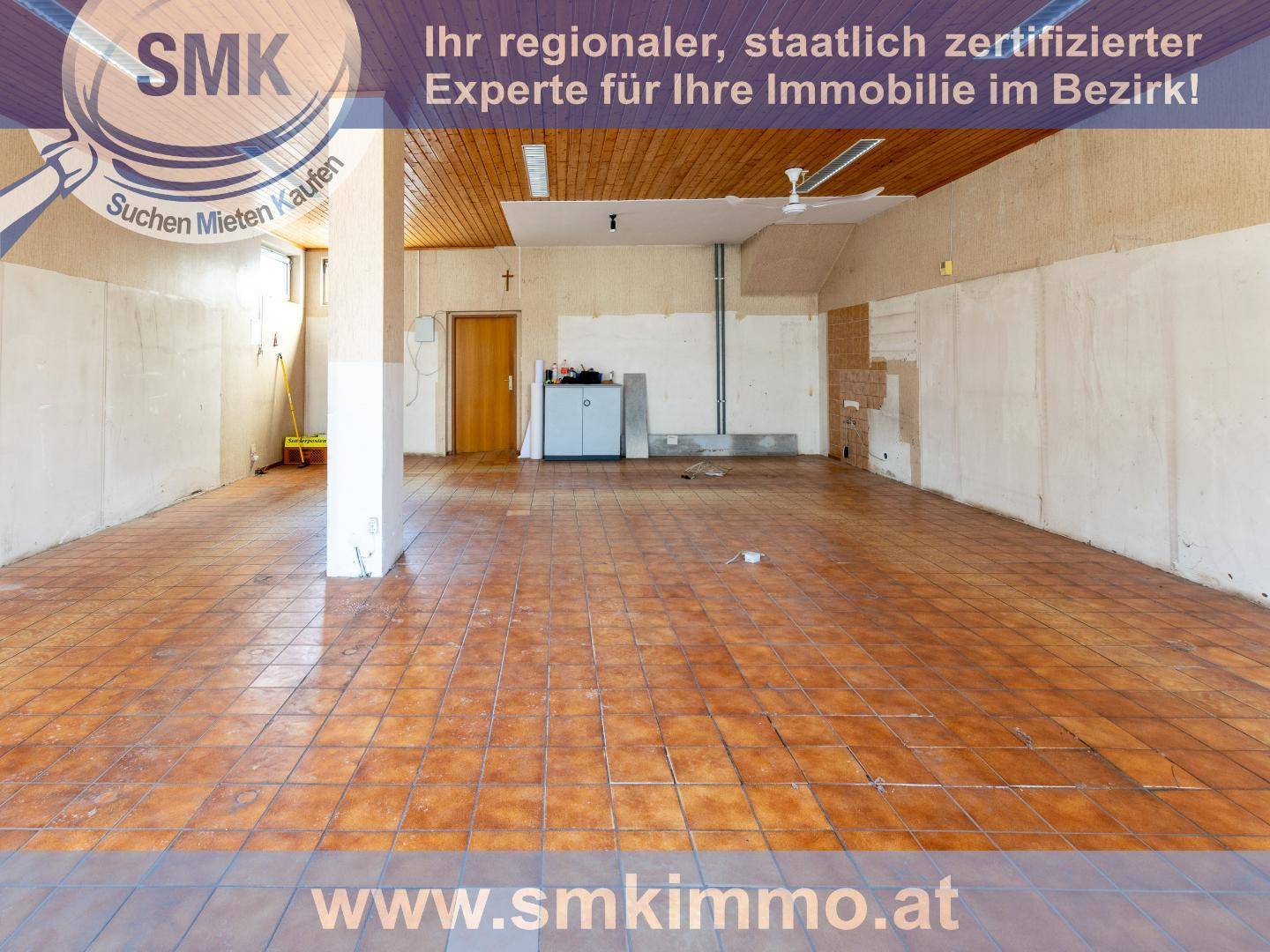 Großer leerer Raum mit Fliesenboden und Holzdecke, möglicherweise für gewerbliche Nutzung.