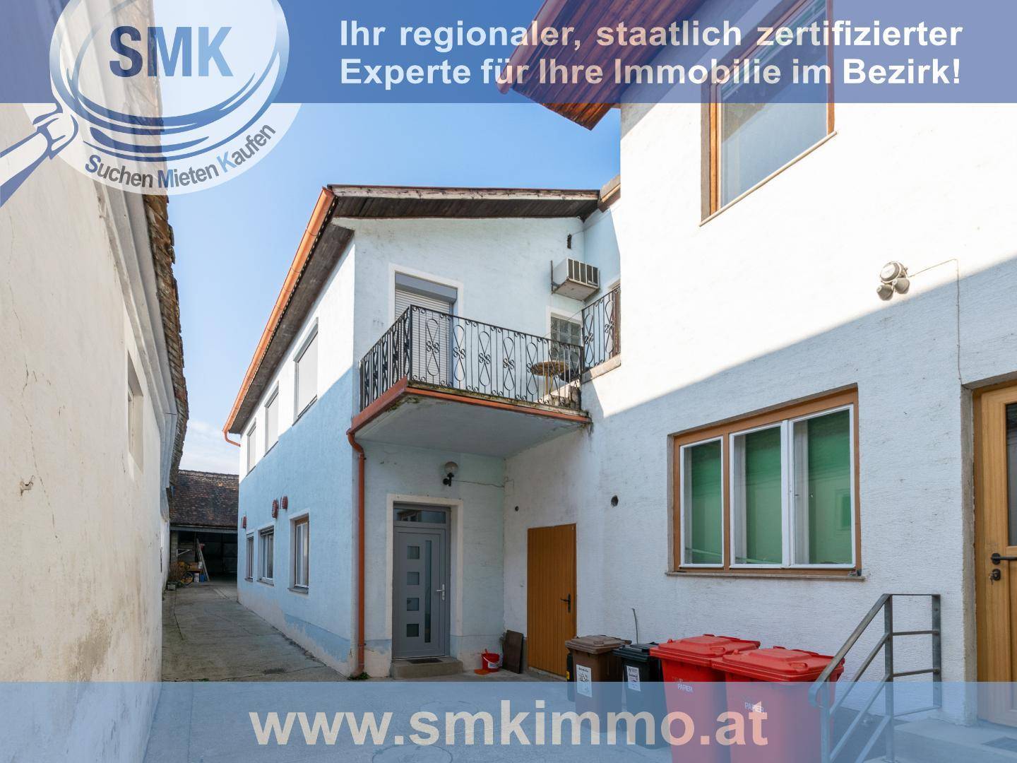 Rückansicht des Gebäudes mit kleinem Balkon und Nebeneingang.