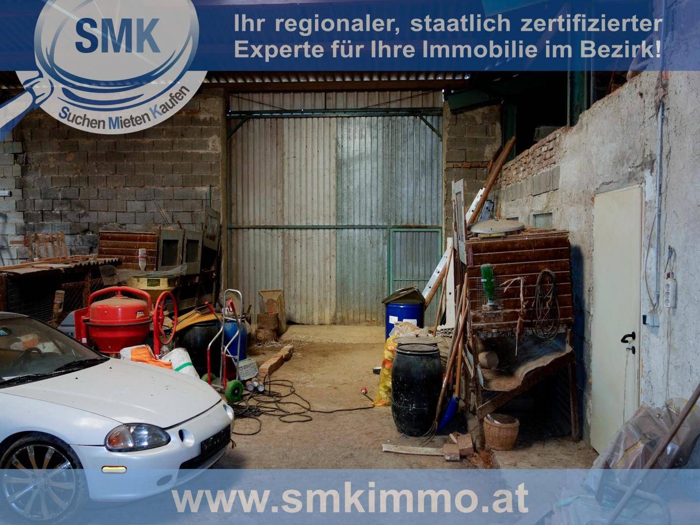 Große, rustikale Garage oder Scheune mit einem Auto, Werkzeugen und einem großen Metalltor.