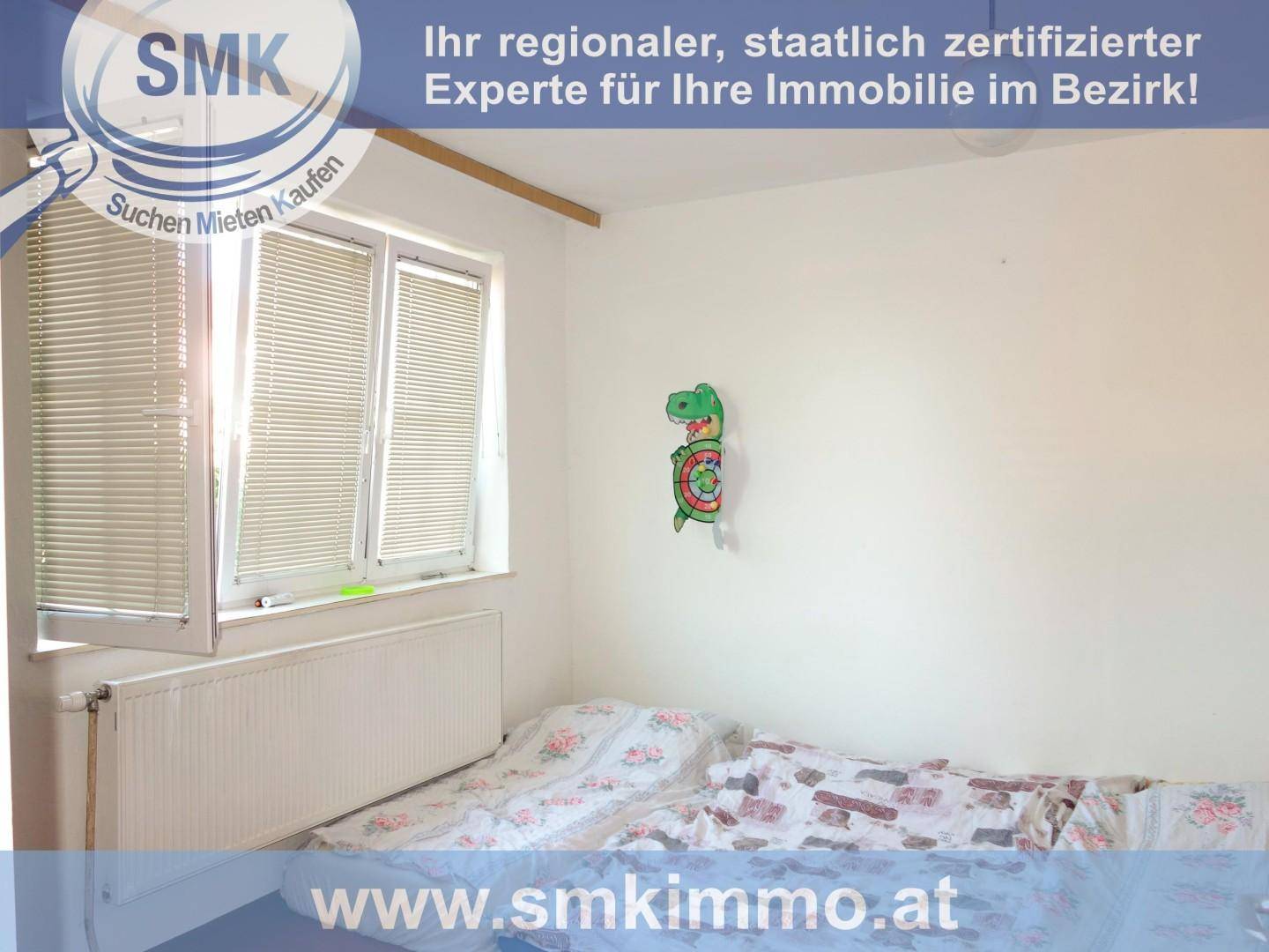 Einfaches Schlafzimmer oder Kinderzimmer mit einem Bett und einem Fenster, hell und schlicht eingerichtet.