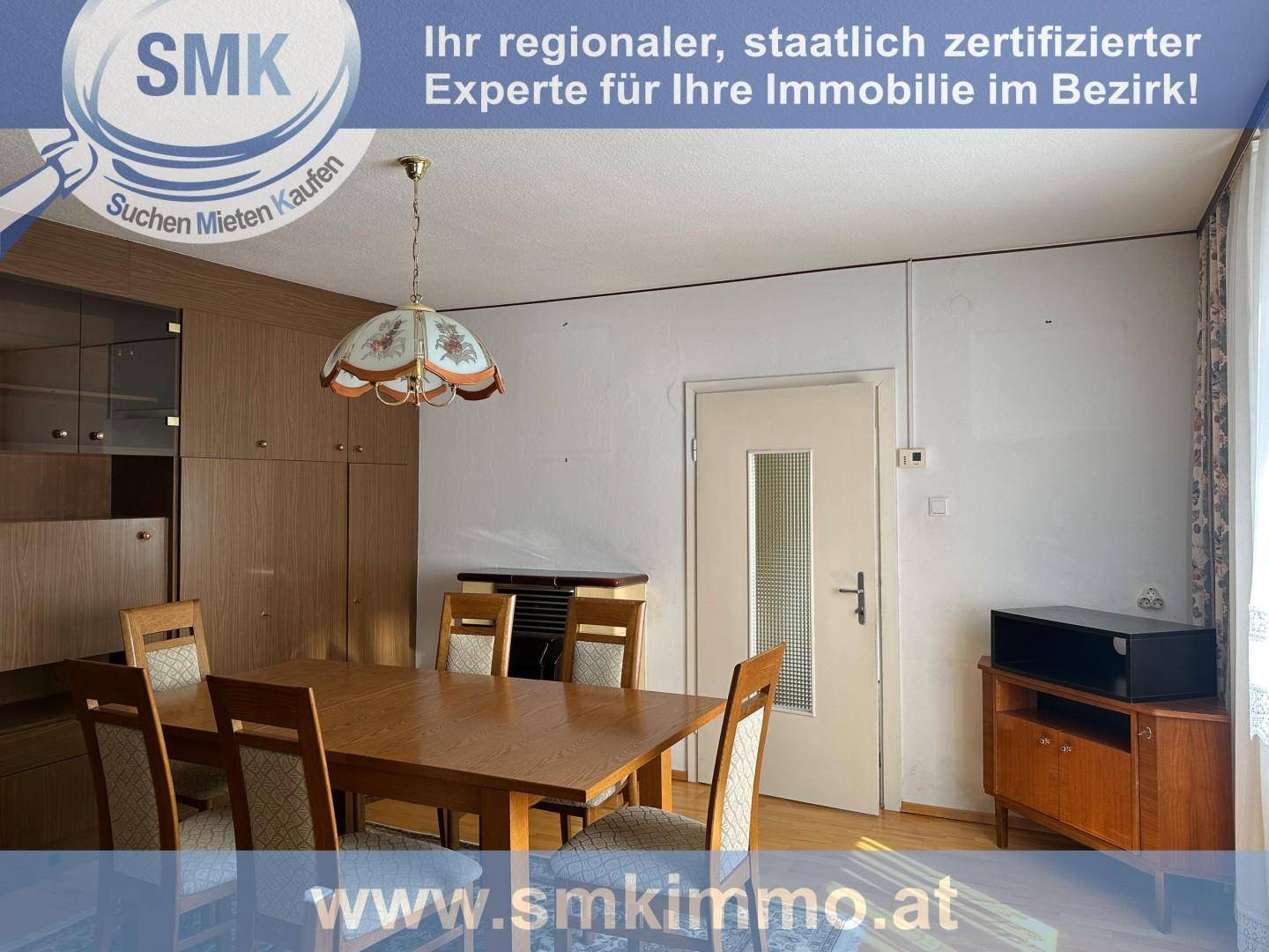 Esszimmer mit Holzmöbeln, einem großen Esstisch und einem traditionellen Kronleuchter.