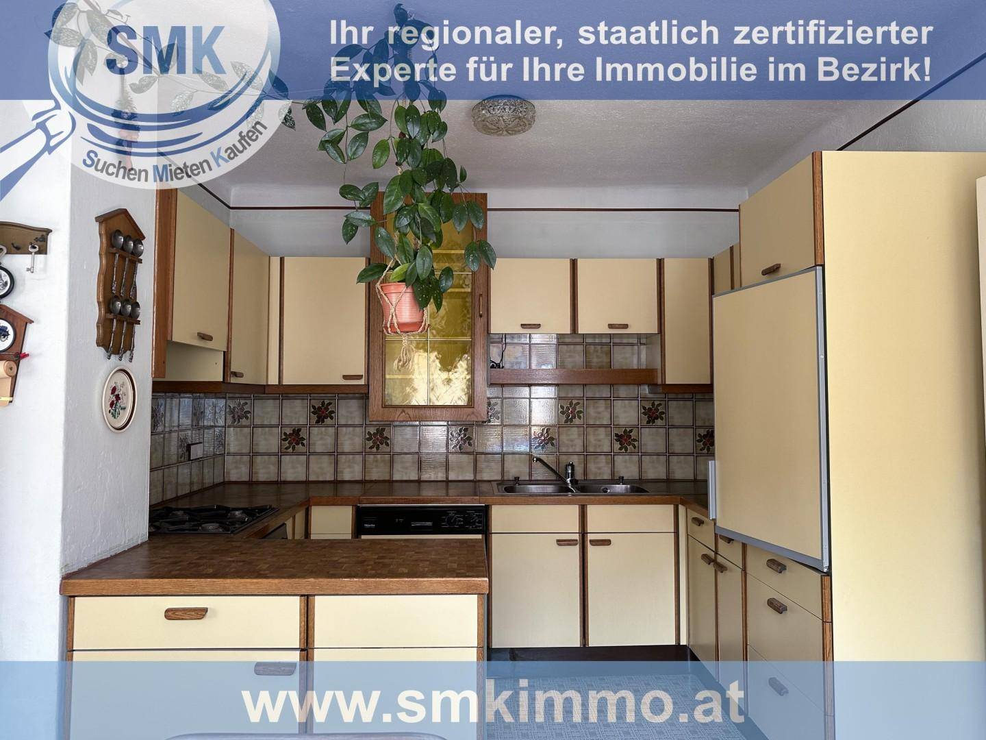 Funktionale Küche im Landhausstil mit beigen Schränken und gemusterten Fliesen.