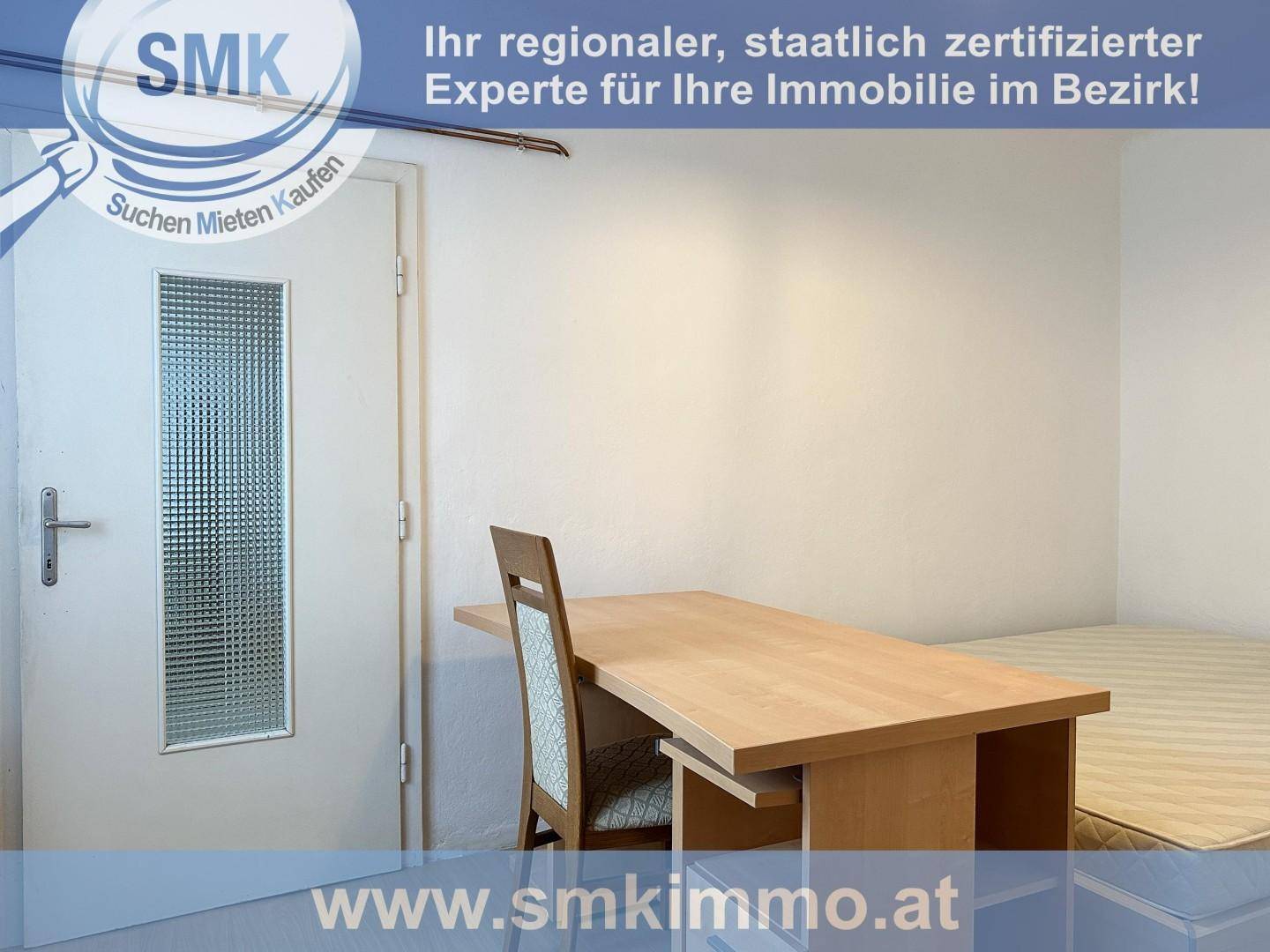 Einfaches Schlafzimmer mit Einzelbett, Schreibtisch und heller Wandgestaltung.