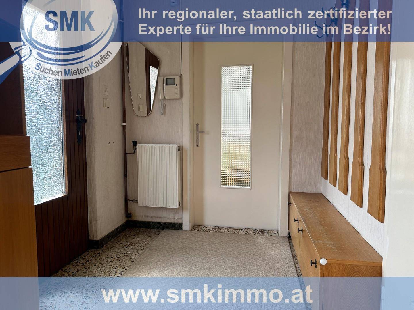 Eingangsbereich mit Garderobe, Spiegel und Fliesenboden in hellem Design.