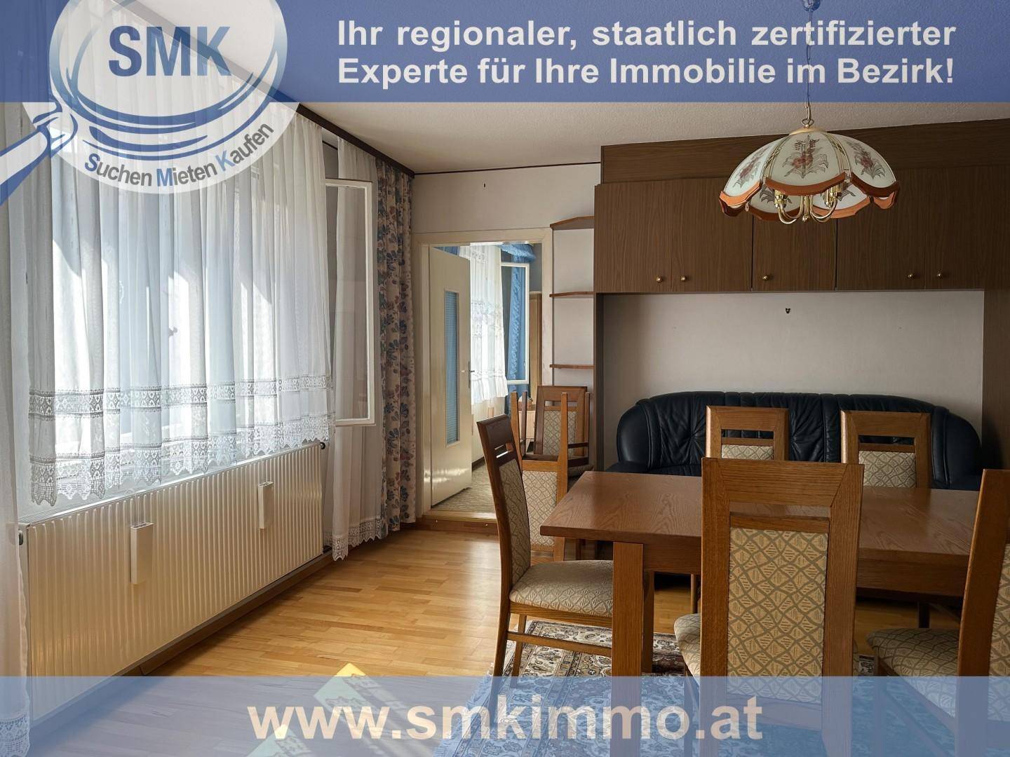 Heller Wohn- und Essbereich mit Holzfußboden, großem Fenster und traditionellen Möbeln.