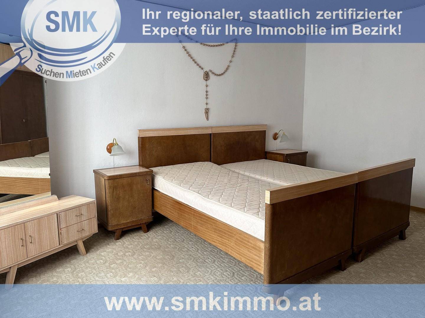 Schlafzimmer mit zwei Einzelbetten, Nachttischen und einem Kleiderschrank im Vintage-Stil.