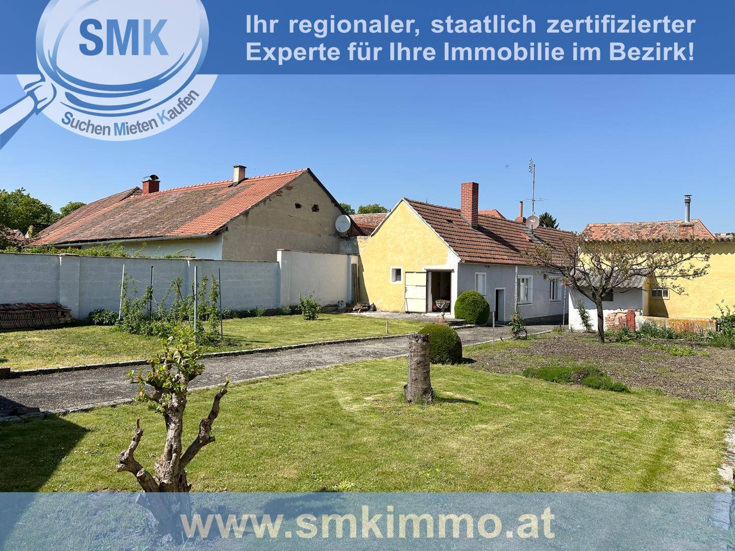 Großer Gartenbereich mit Rasenfläche und Blick auf die umliegenden ländlichen Gebäude.