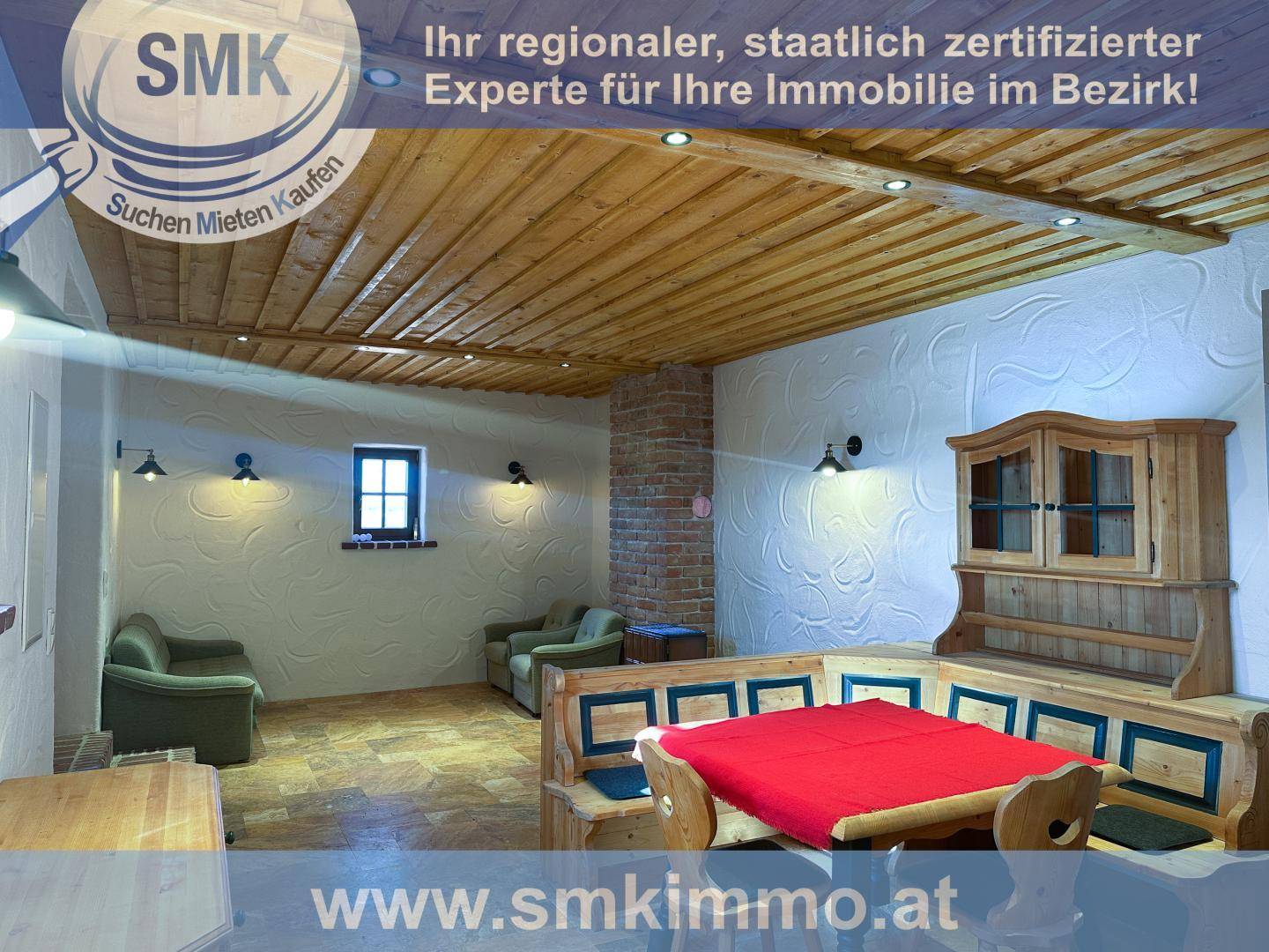 Rustikales Wohnzimmer mit Holzbalkendecke, strukturierten Wänden und traditionellen Holzmöbeln.