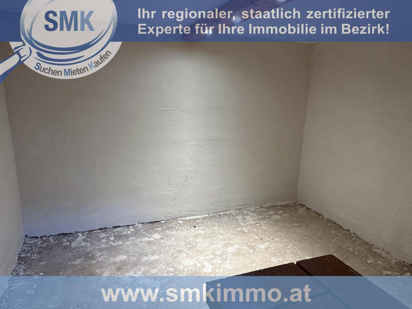 Leerer Raum mit strukturierten weißen Wänden und einem einfachen Betonboden.