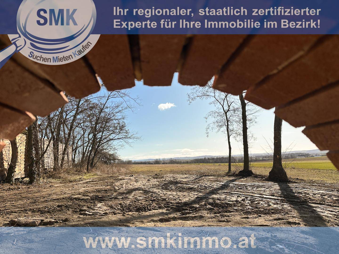 Weitläufiger Blick über Felder und ländliche Landschaft unter blauem Himmel.