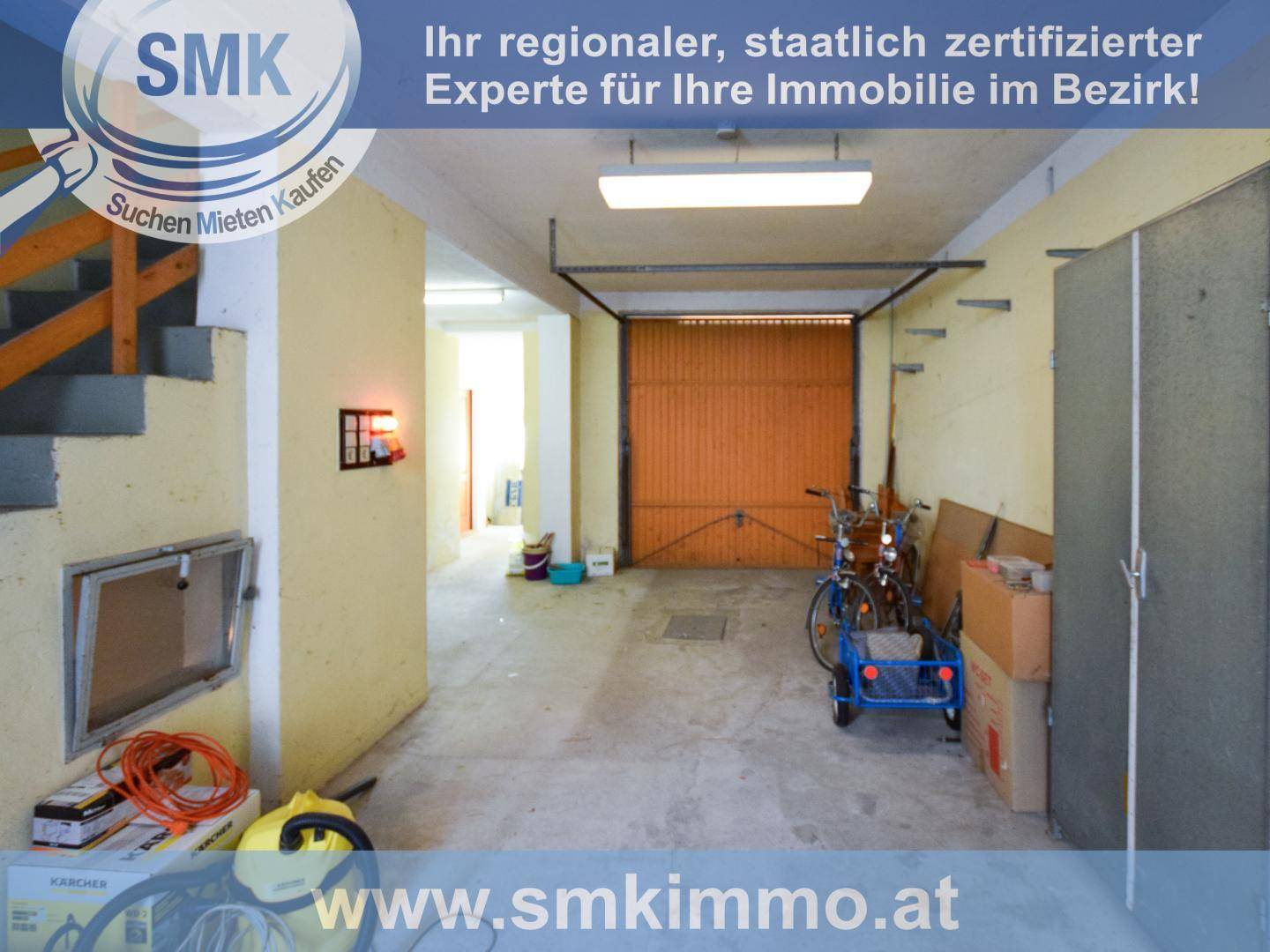 Geräumige Garage mit Betonboden, Rolltor und Abstellmöglichkeiten für Fahrräder.