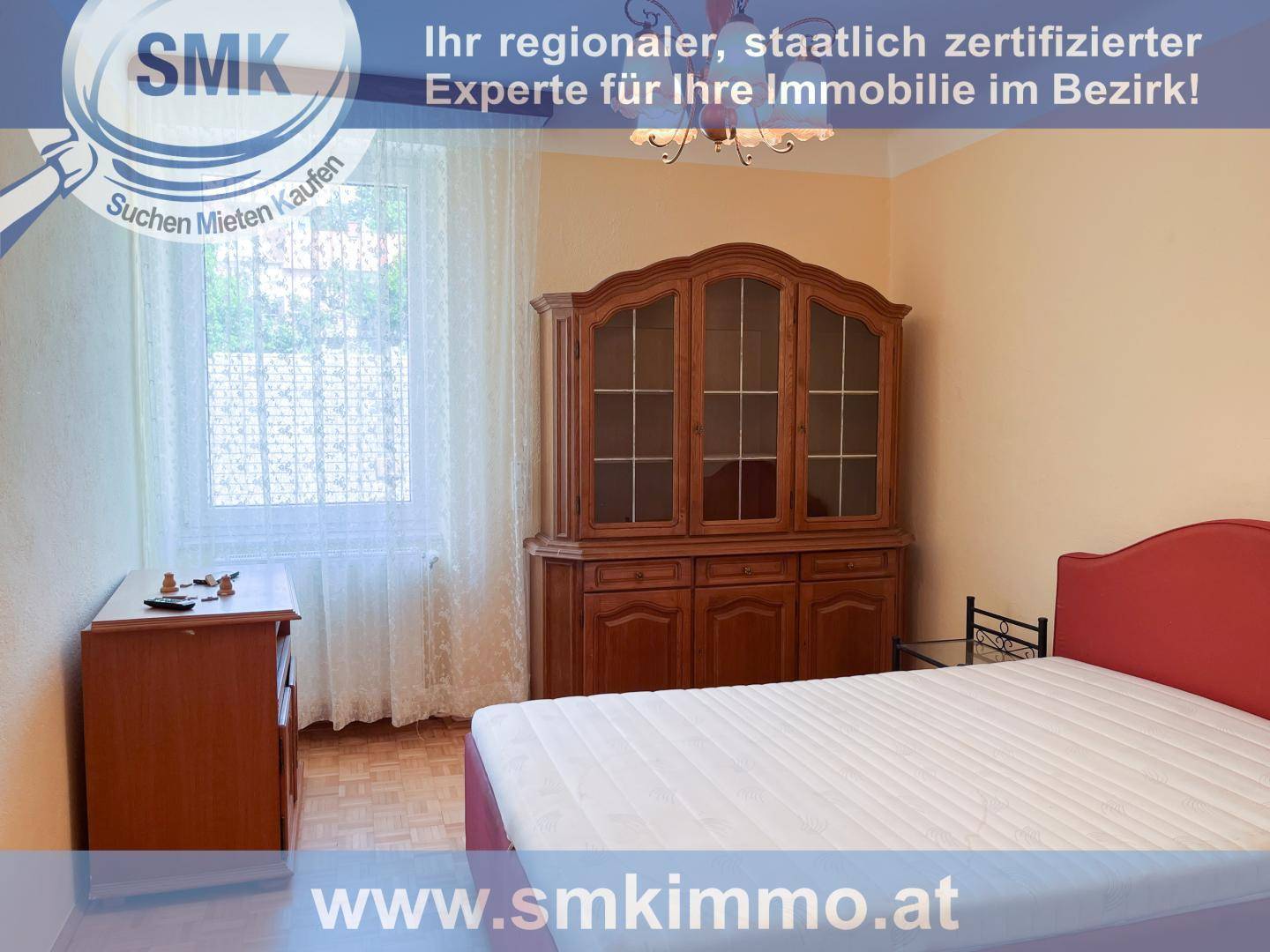 Gemütliches Schlafzimmer mit Holzboden, großem Schrank und Fenster mit Vorhängen.