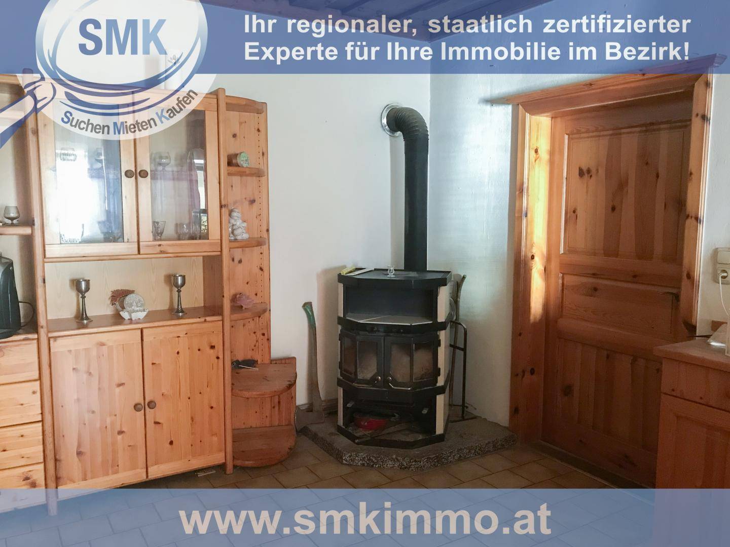 Gemütlicher Innenraum mit Holzmöbeln, einem Kaminofen und Holztüren.