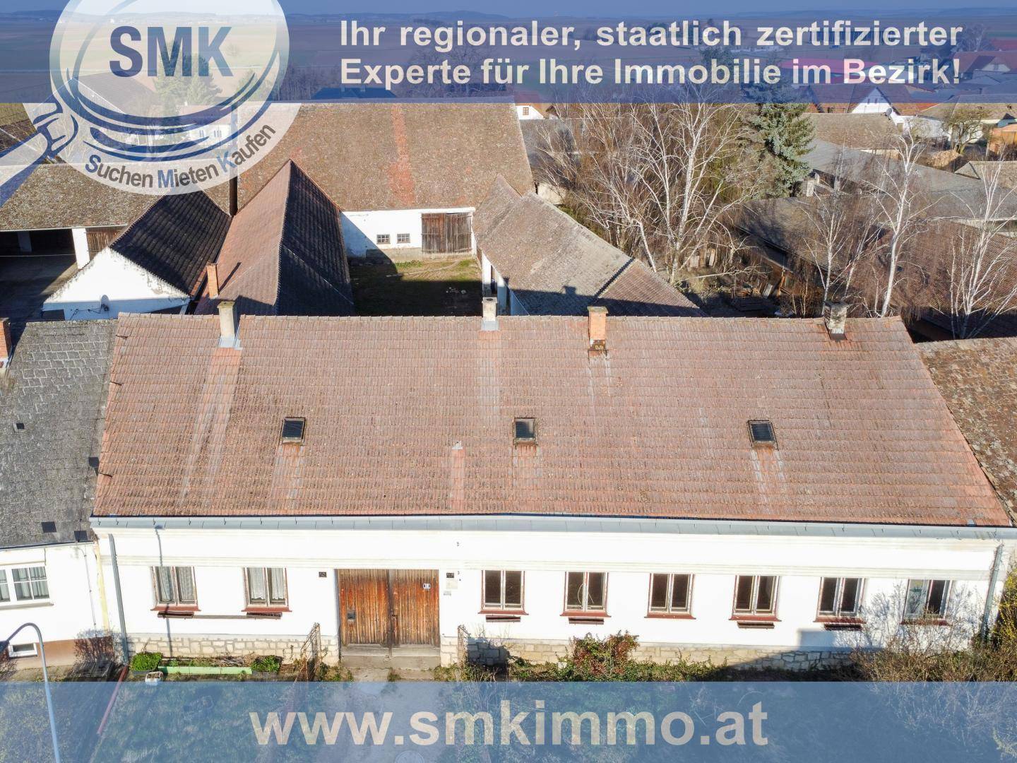 Luftaufnahme des Hauptgebäudes mit Nebengebäuden und Dächern, eingebettet in ländliche Umgebung.