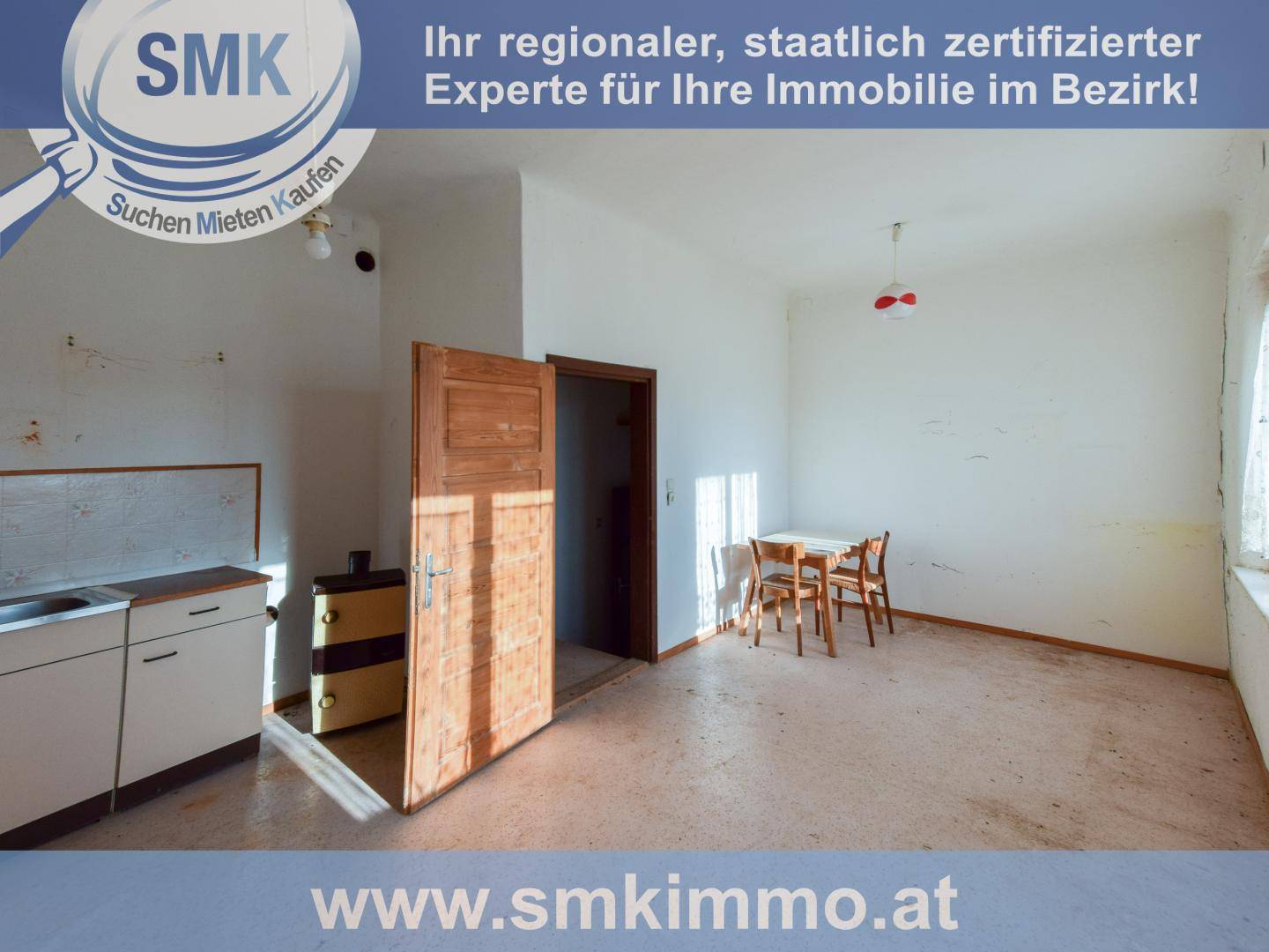 Kleine Wohnküche mit einfacher Küchenzeile und einem Esstisch, hell durch ein Fenster.