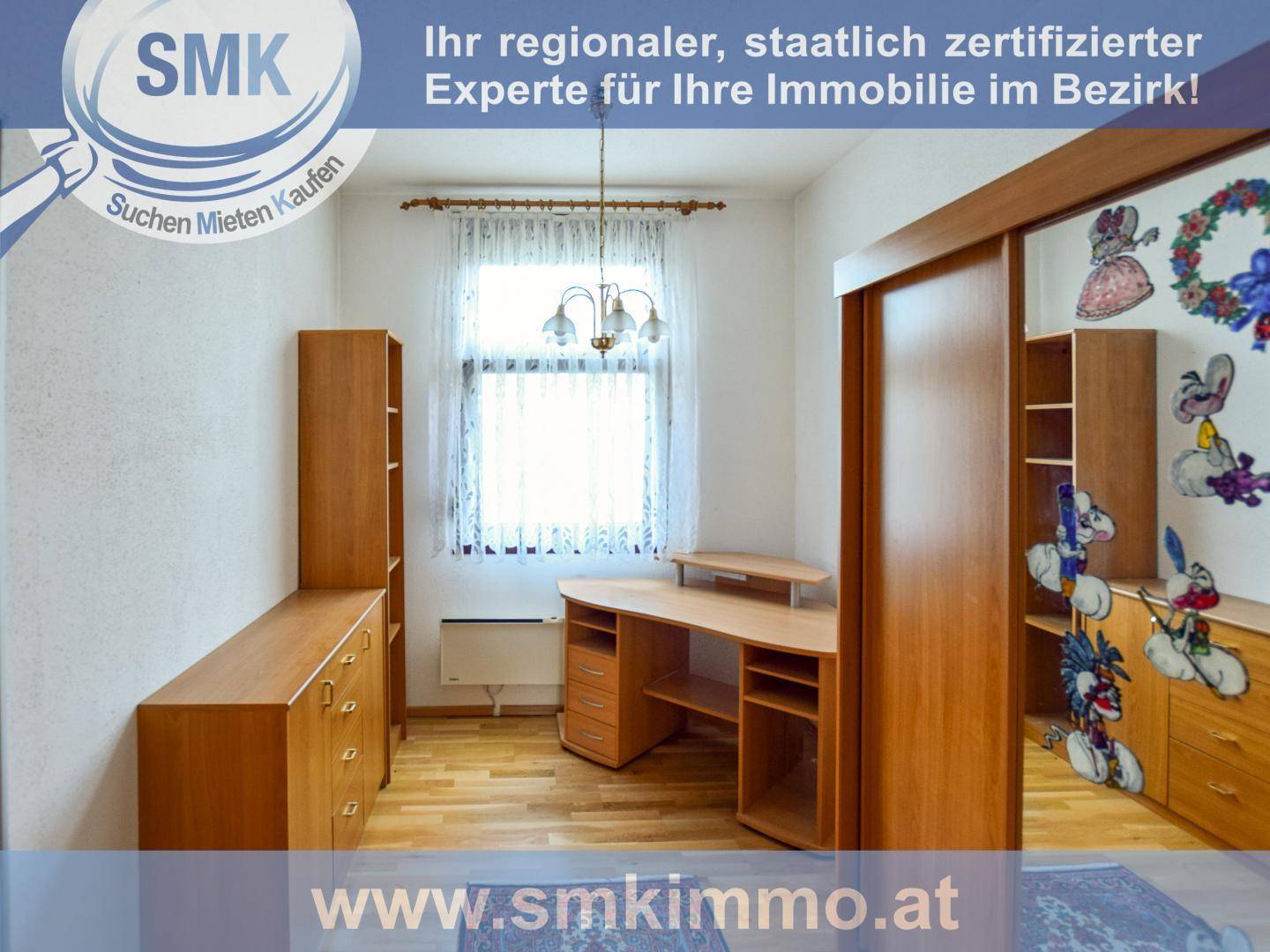 Helles Zimmer mit Schreibtisch, Regalen und dekorativer Schiebetür.