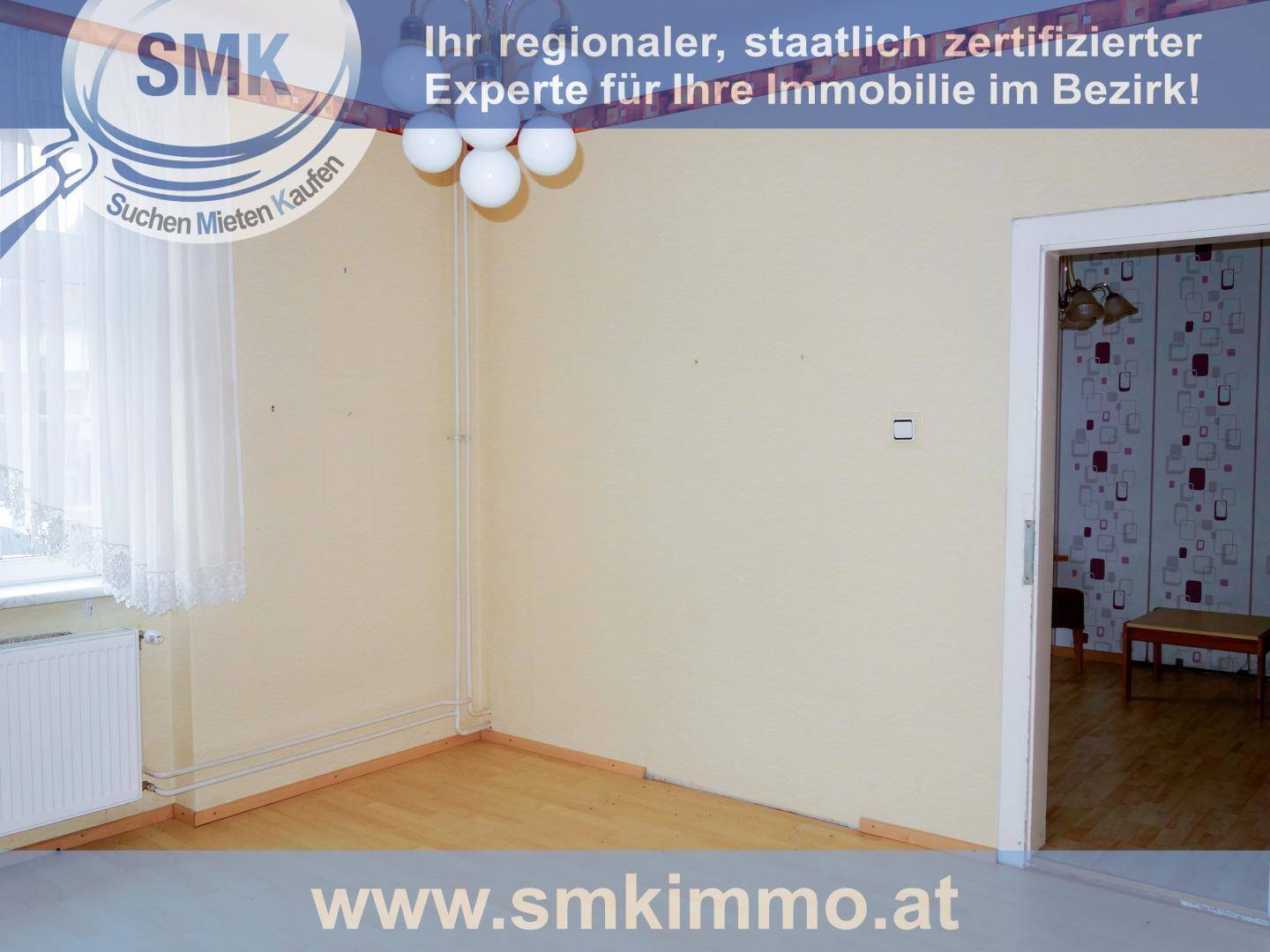 Leerer Raum mit hellem Laminatboden, weißen Wänden und Fenster, bereit zur individuellen Gestaltung.