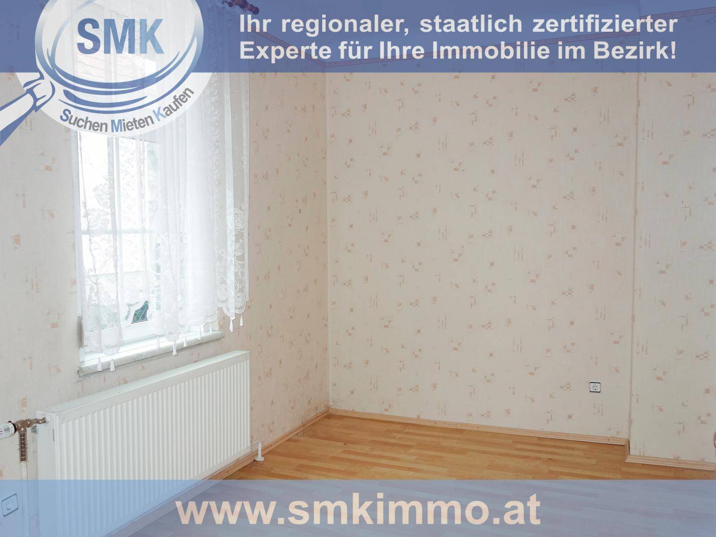 Helles Zimmer mit Laminatboden, gemusterter Tapete und großem Fenster für viel Tageslicht.