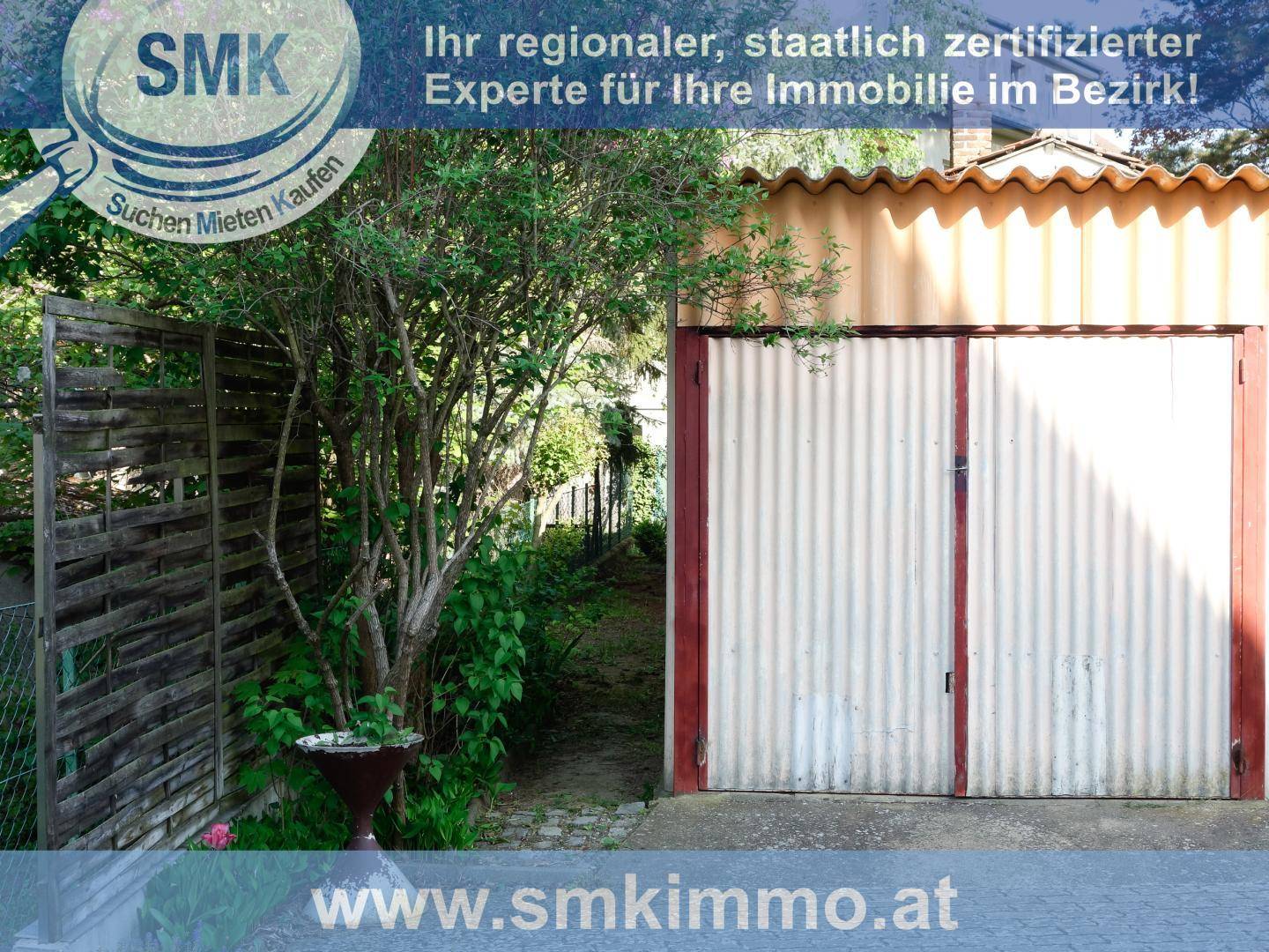 Einzelgarage mit Wellblechtoren und umgebender Vegetation, bietet Platz für ein Fahrzeug.