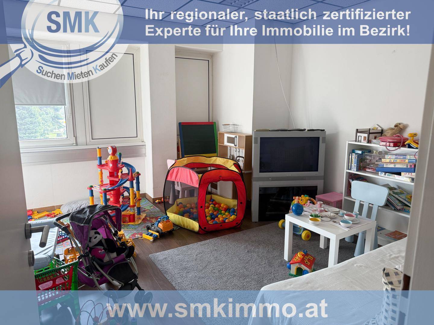 Helles Spielzimmer mit vielfältigem Kinderspielzeug, Teppich und einem Fenster.
