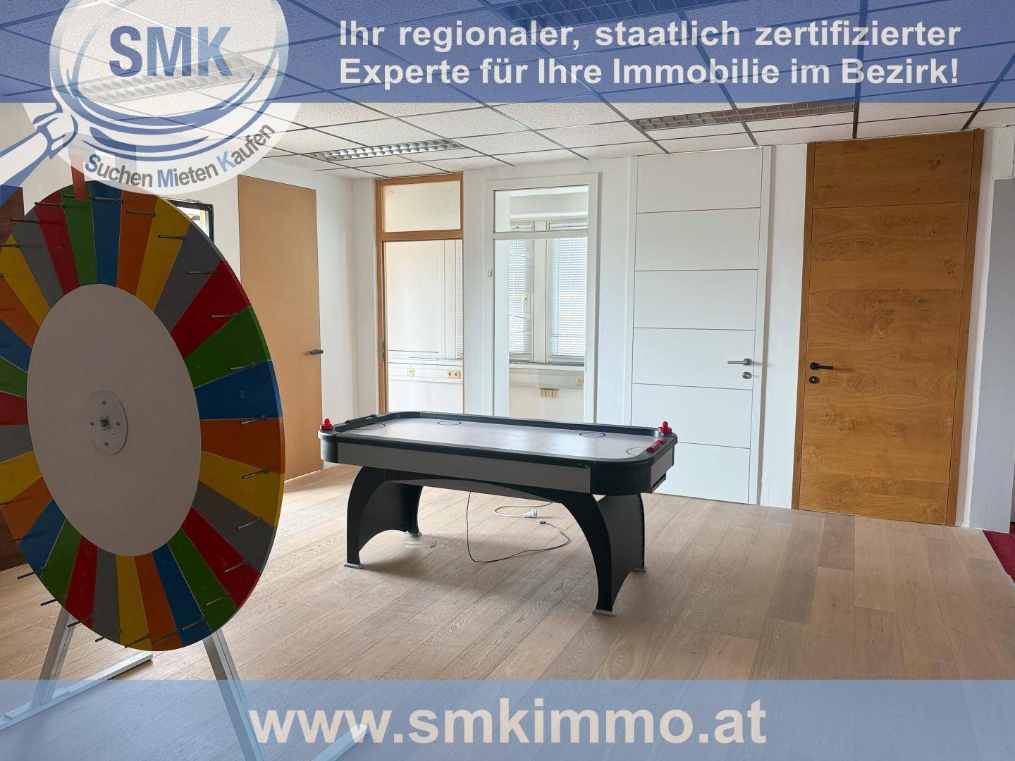 Freizeitraum mit Airhockey-Tisch und Glücksrad, ausgestattet mit Holz- und Teppichboden.