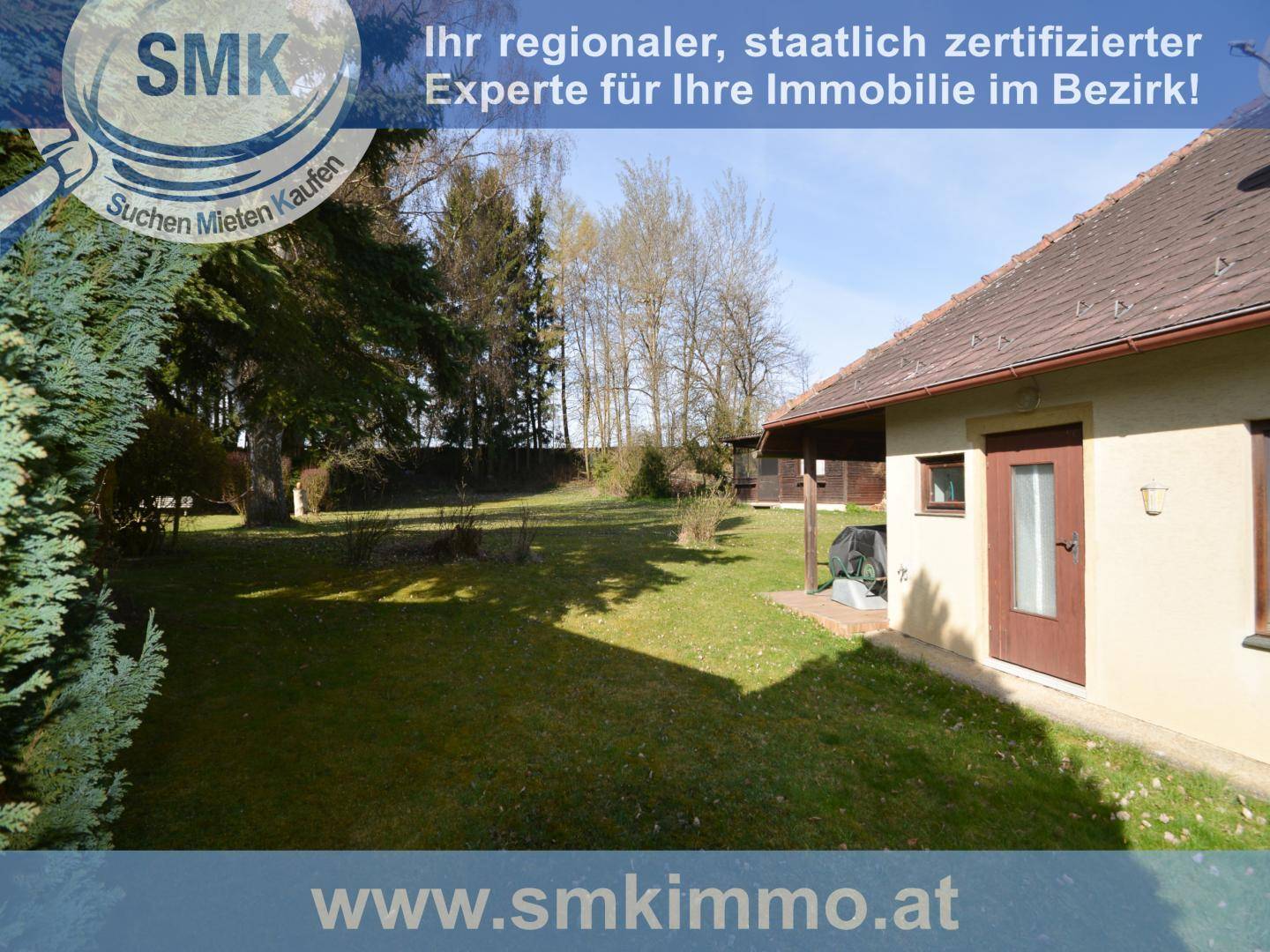 Großer, gepflegter Garten hinter dem Haus mit Rasenfläche und Bäumen.