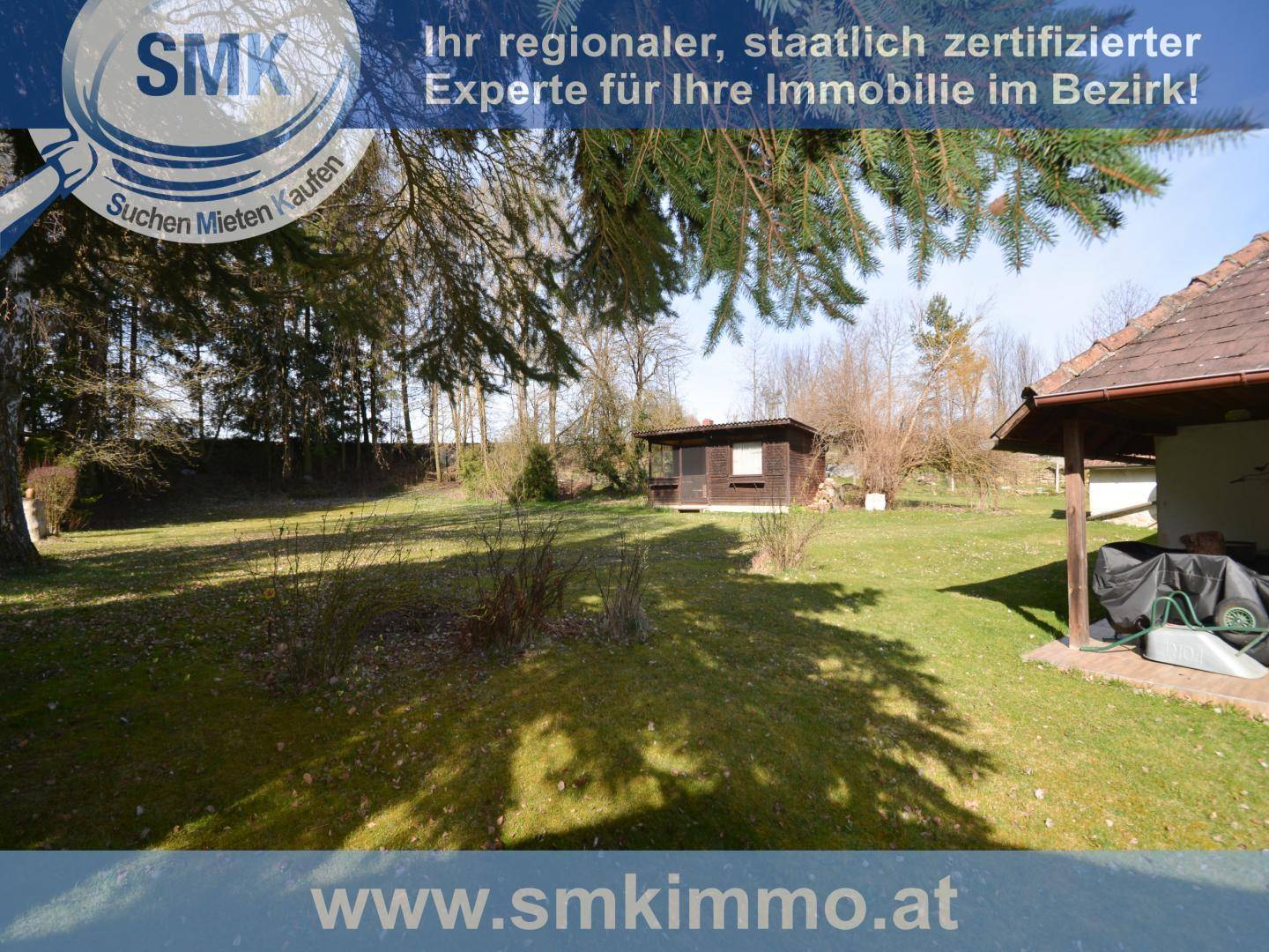 Weitläufiger Garten mit Rasenfläche, Bäumen und einem kleinen Gartenhaus.