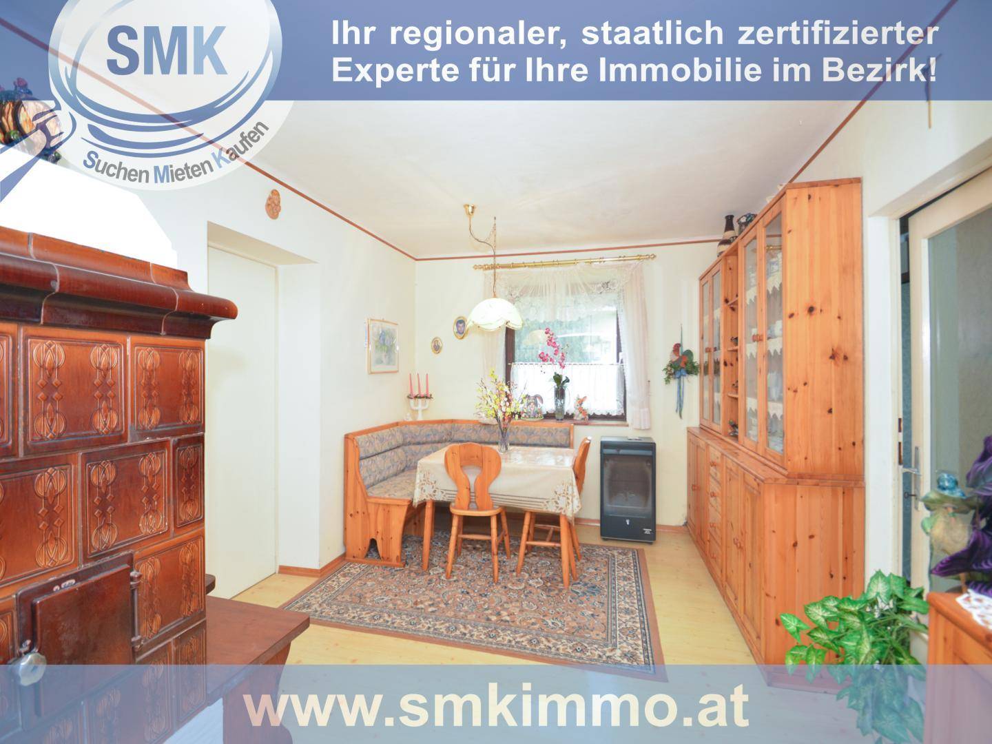 Gemütlicher Essbereich mit traditionellem Kachelofen und Holzmöbeln.