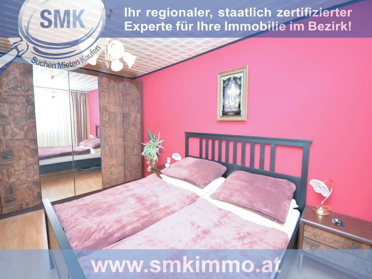 Schlafzimmer mit pinken Wänden, Doppelbett und Spiegelschrank.