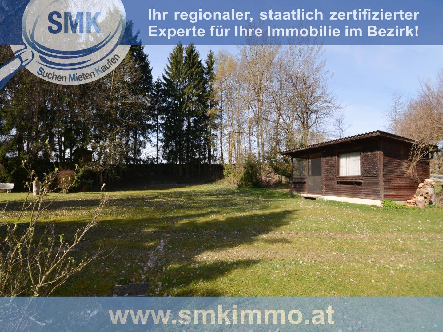 Großer Garten mit Rasenfläche, umgeben von Bäumen und einem Holzschuppen.