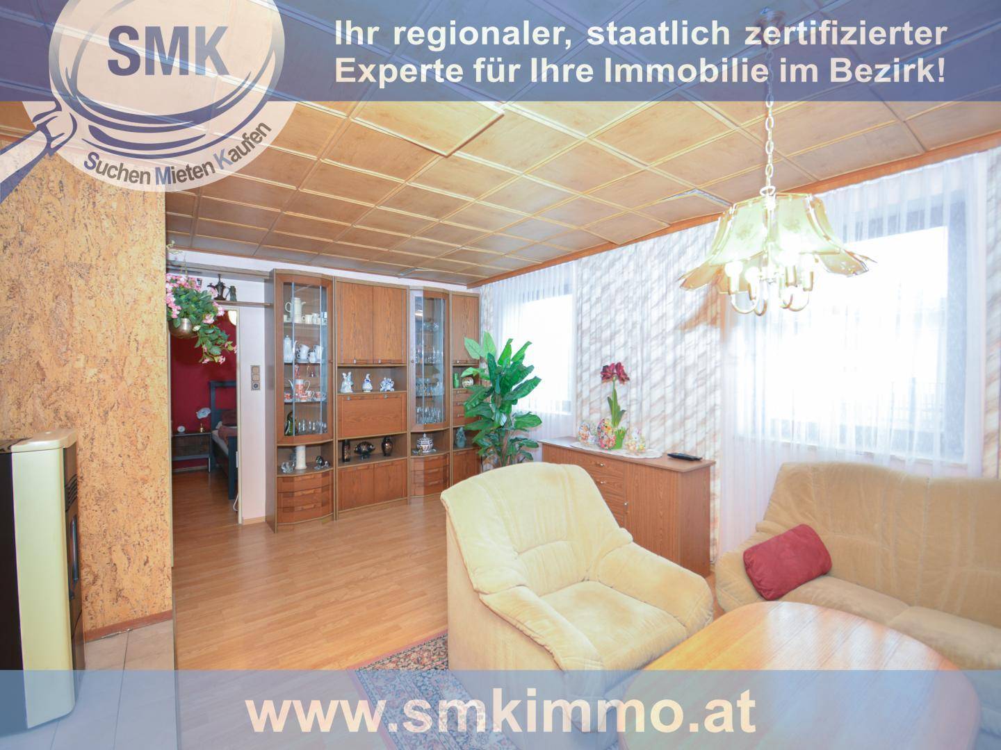 Wohnzimmer mit Holzdecke, bequemen Sesseln und großem Schrank.