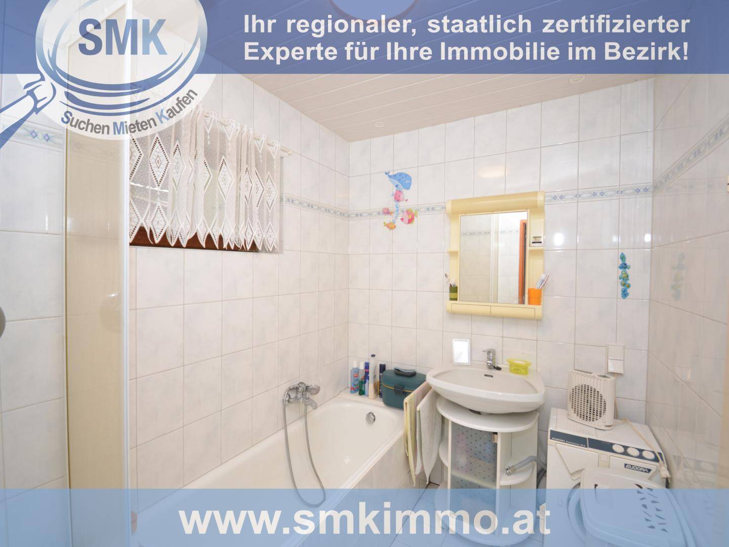 Badezimmer mit Badewanne, Waschbecken und weißen Fliesen.