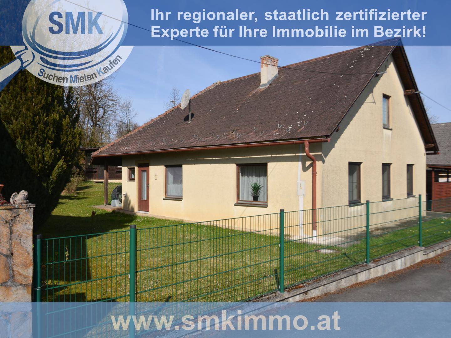 Gepflegtes Einfamilienhaus mit Satteldach und grünem Vorgarten unter blauem Himmel.
