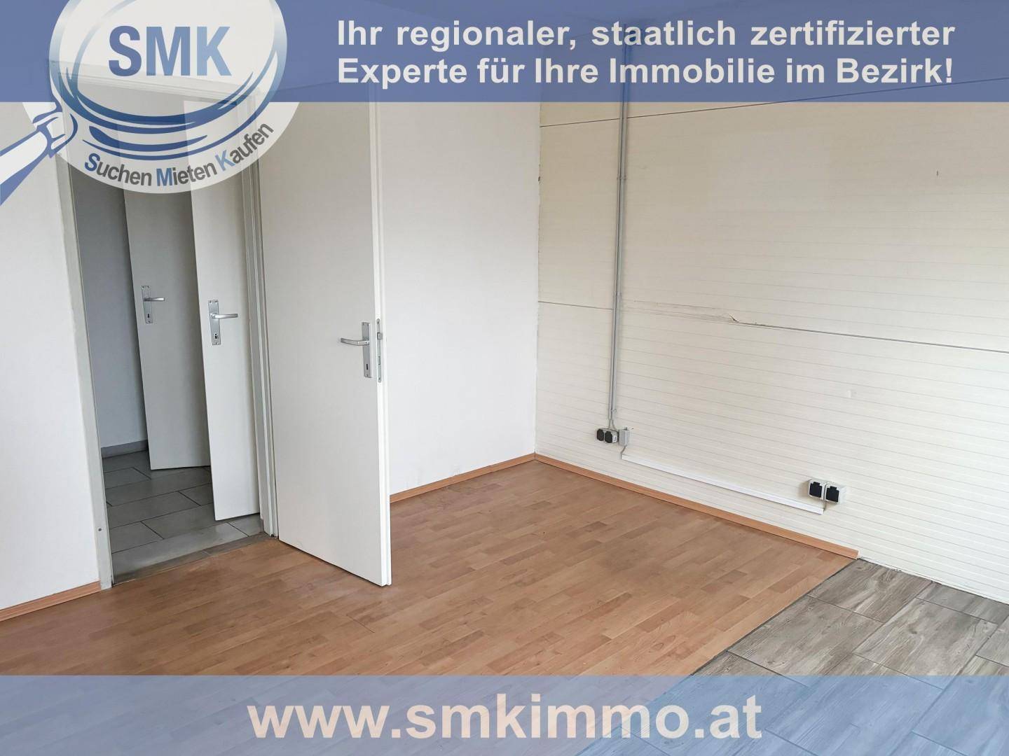 Leerer Raum mit Laminatboden und weißen Wänden, der als Büro oder Lagerraum genutzt werden könnte.
