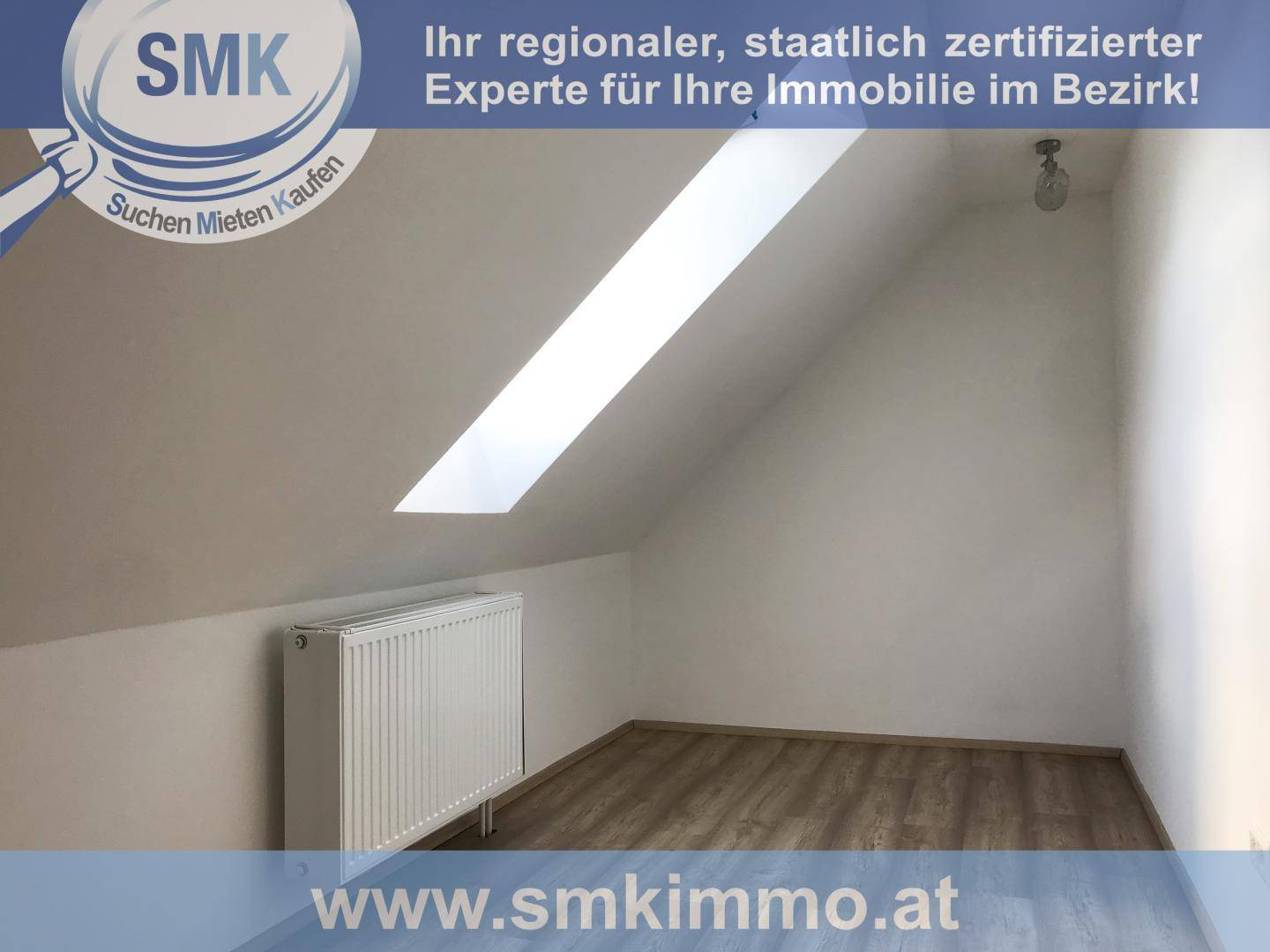 Dachgeschosszimmer mit schräger Decke, Dachfenster und Heizkörper, bietet viel Tageslicht.