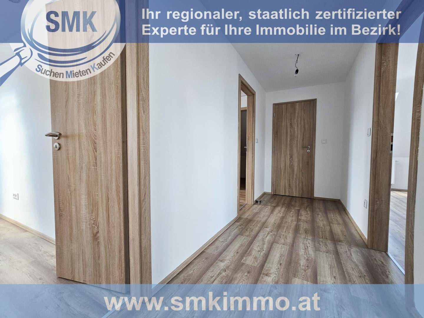 Geräumiger Flur mit hellem Laminatboden und mehreren Türen zu angrenzenden Räumen, unmöbliert.