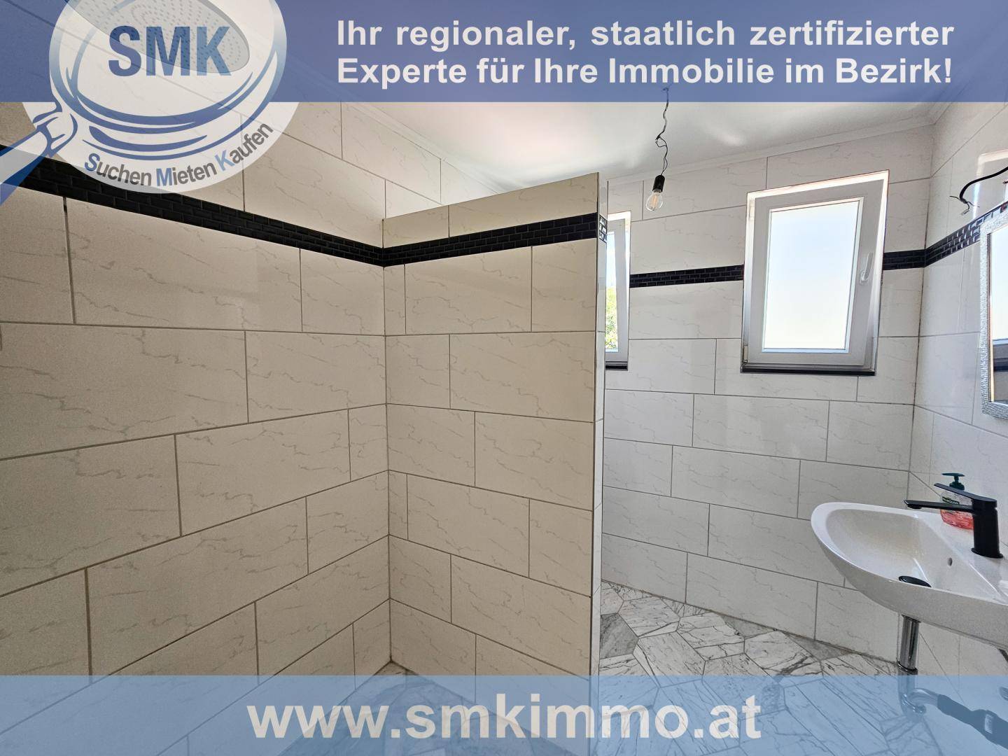Modernes Badezimmer mit weißen Fliesen, begehbarer Dusche und Einzelwaschbecken, hell und funktional.