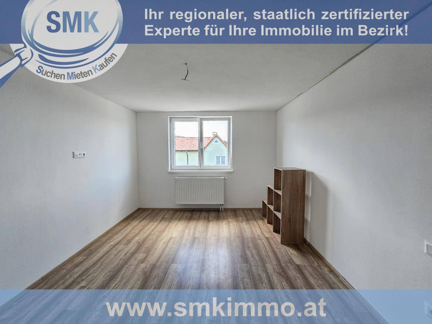 Leerer Raum mit Laminatboden, großem Fenster und Heizkörper, ideal als Schlaf- oder Arbeitszimmer.