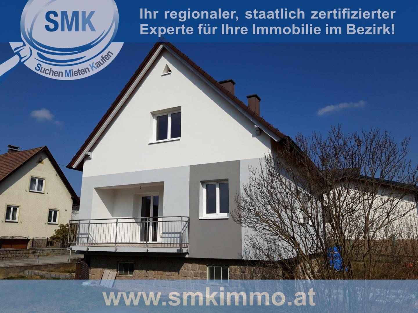 Seitenansicht eines Einfamilienhauses mit kleinem Balkon und moderner Fassadengestaltung in Hellblau und Grau.
