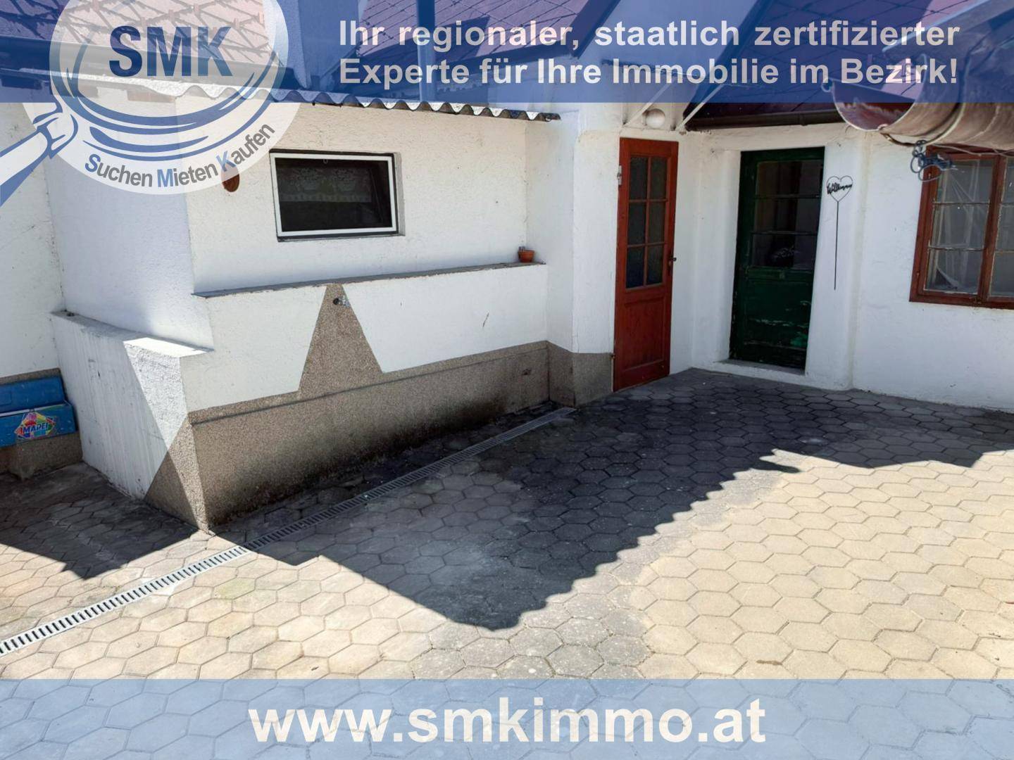 Gepflasterter Außenbereich mit Zugang zu zwei Türen, ideal für eine Terrasse.