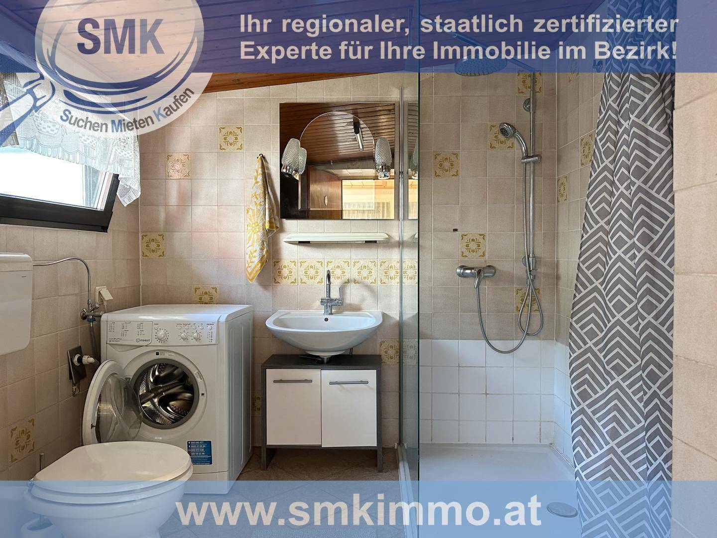 Badezimmer mit Dusche, WC, Waschbecken und Waschmaschine, geflieste Wände.
