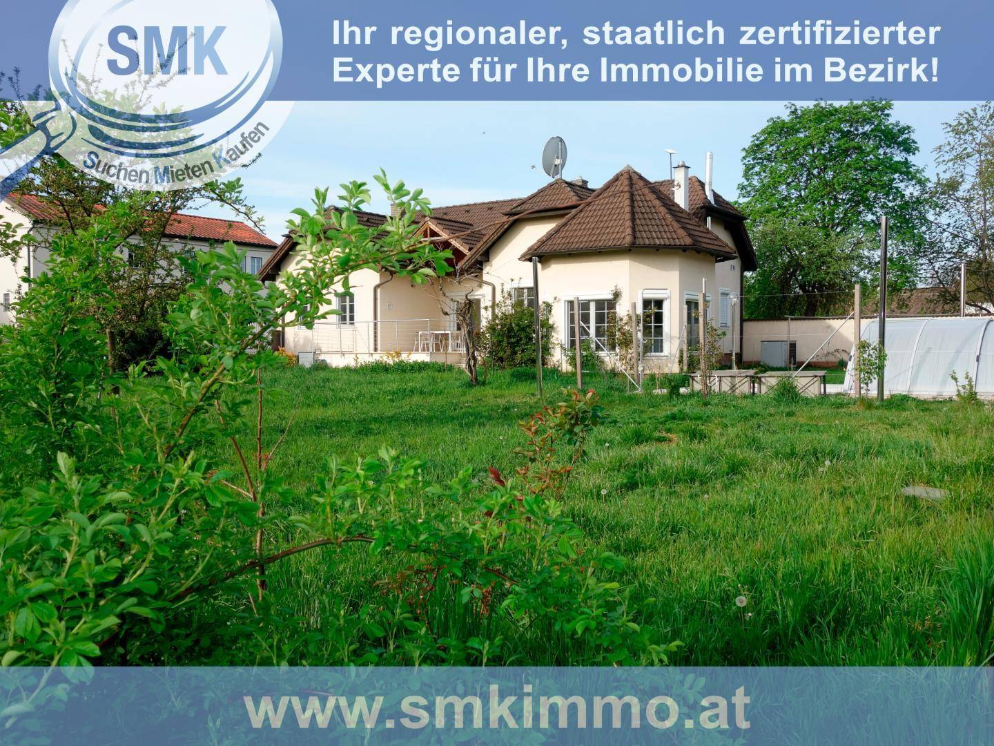 Großer Garten mit Rasenfläche und Blick auf das Einfamilienhaus im Hintergrund.